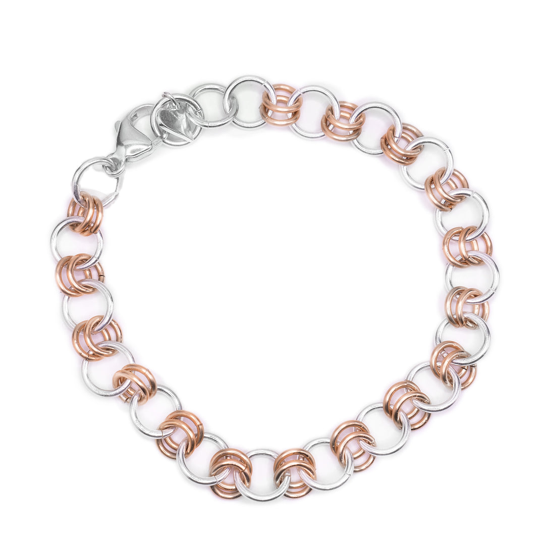 This sterling silver and 14K gold fill chain bracelet has larger silver links and small gold links. The piece is made of double, gold links connected by single, silver links.