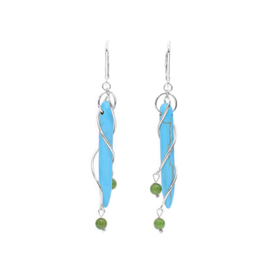 These dangling turquoise earrings are made from turquoise gemstones, BC jade and sterling silver. These drop earrings have thin turquoise gems with silver wires and jade beads wrapping around them.