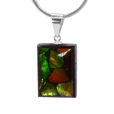 This ammolite pendant is made by setting pieces of ammolite in a rectangle box. The pendant dangles from a sterling silver jump ring.