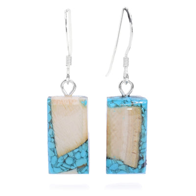 These dangling turquoise earrings are made from fossilized mammoth ivory and turquoise gemstone. The hangs are rectangular and have pieces of the turquoise and chunks of the ivory set into resin.