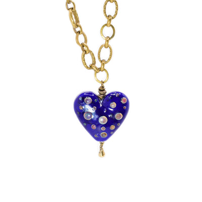 Thick brass chain with dark blue handmade lampworked glass heart pendant. Heart has colourful dots. By Wendy Pierson.