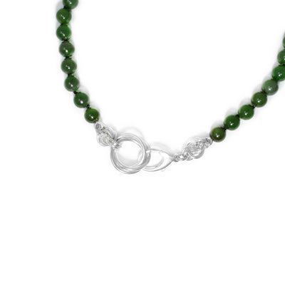 Knotted BC jade bead necklace that can double as a bracelet when wrapped around the wrist once. The clasp and surrounding adornments are made of sterling silver rings.