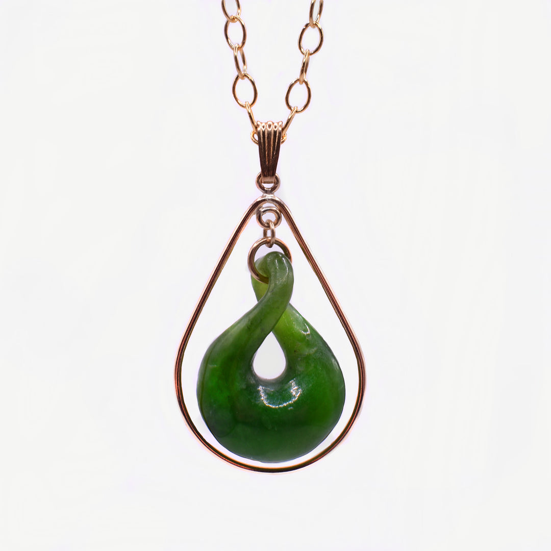 This BC Jade Teardrop Necklace pendant features a smooth teardrop-shaped piece of BC jade with a twist in its center. A Gold Filled frame, also in a teardrop shape, surrounds the jade, with smooth lines that add elegance while giving the piece a delicate, refined look.