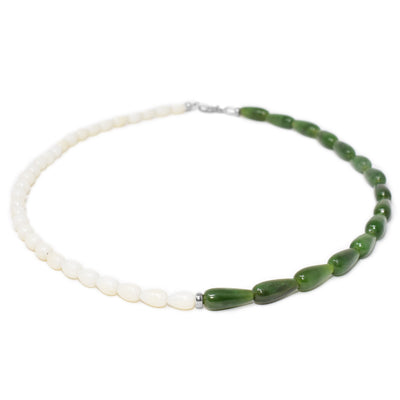 Necklace with petite, horizontal white coral teardrop beads on right and long, horizontal BC jade teardrop beads on left. Separated by cylindrical sterling silver bead in middle.