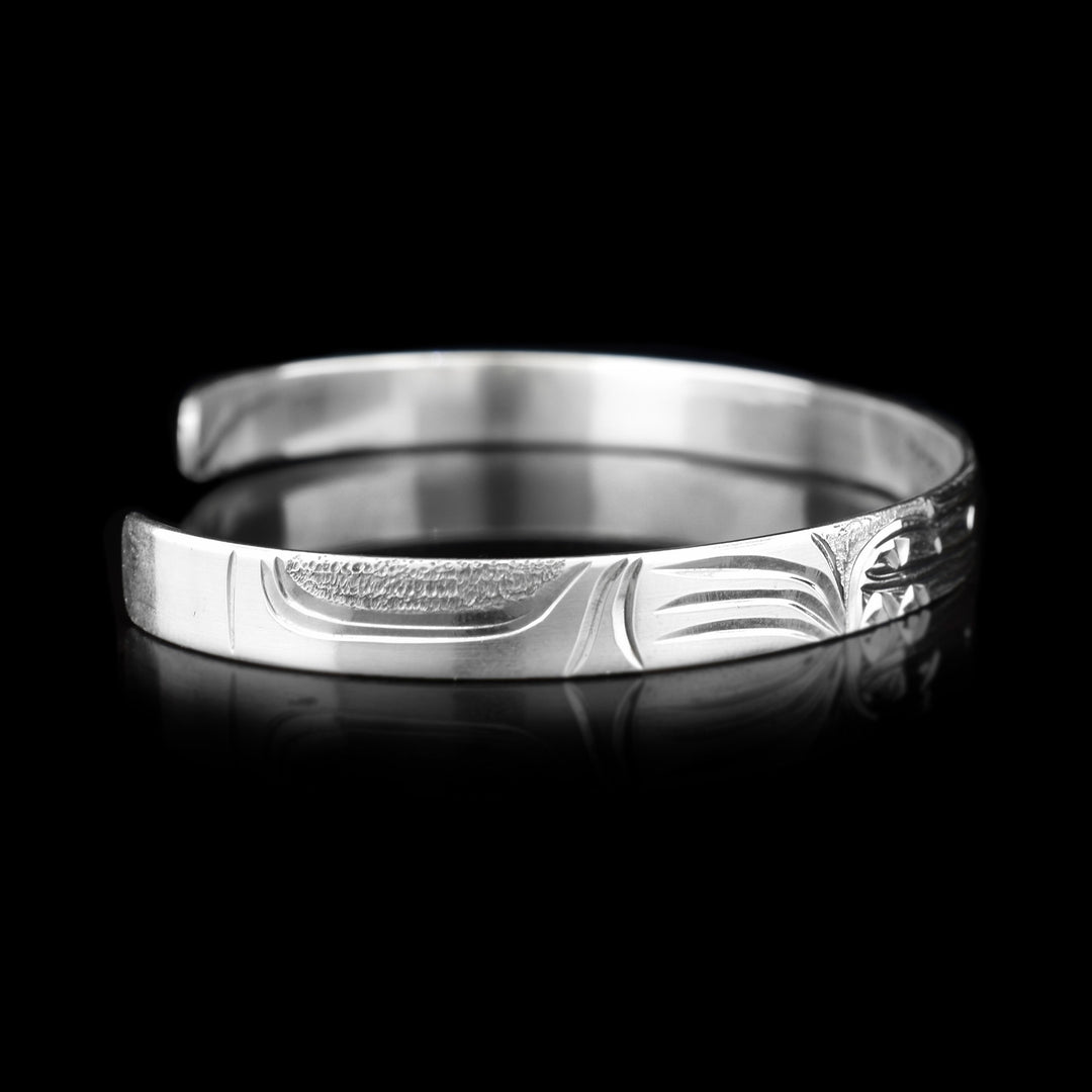 Left angle photo of the cuff bracelet depicts carvings representing the large paw of the bear.