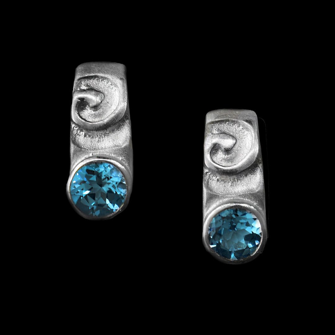 These elegant earring are studs/small drop earrings. The top of the silver earing as a small swirl and under the swirl is a gem of topaz.