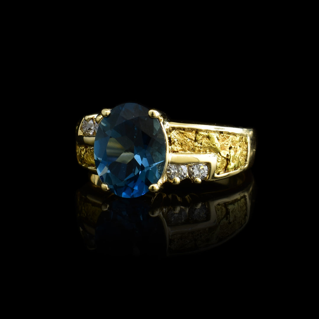 Blue Topaz and Gold Nugget Ring with Diamond Accent. The band is made out of 10k gold and 22k gold nuggets and four small diamonds accent the band and the blue topaz that sits atop of it.
