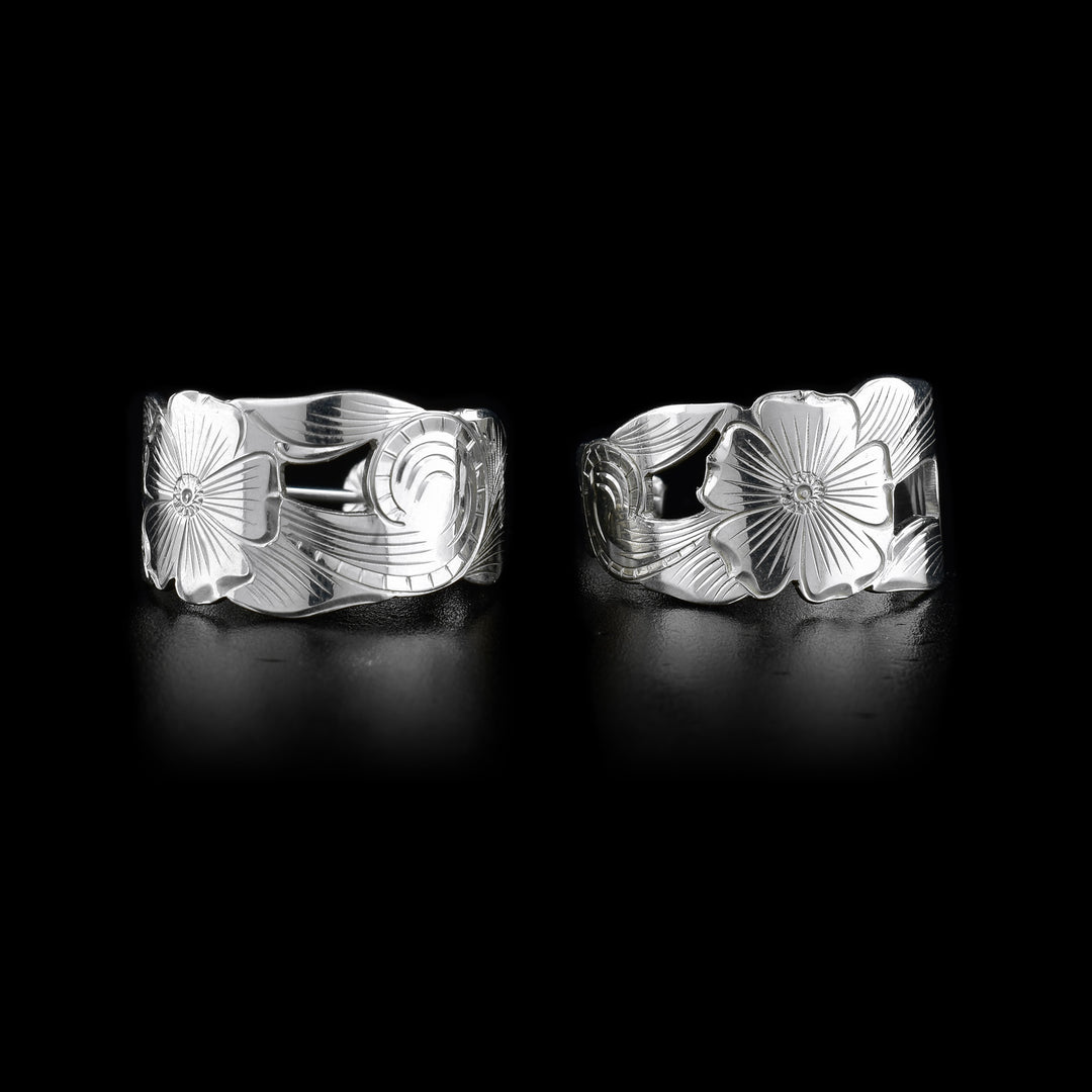 These flower hoop earrings silver are shaped like hoops. In the middle of the hoop, there is a flower handcarved onto it. The rest on the earring depicts vines. The space between the flower and vine is cut out.