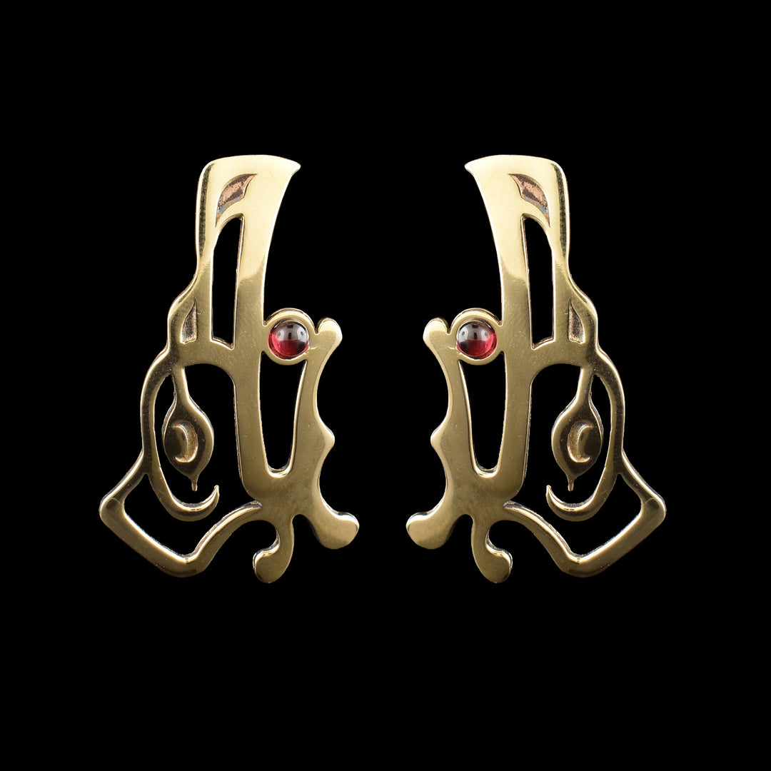 Handcrafted bronze Raven drop earrings by Haida Gwaii artist Gina Mae Schubert. Featuring a red garnet stone, in the mouth of the Raven.