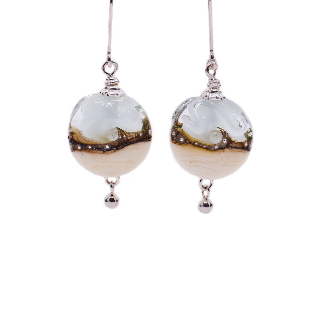 Beige, brown and light blue handmade lampworked glass earrings with silver flecks in middle. Lentil swirl designs along middle. Sterling silver hooks.