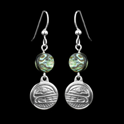 These abalone drop earrings silver have small, circle hangs made from sterling silver. Below the hooks is a single, round abalone shell charm with the hangs dangling from them. On the hangs, the head of the Orca is shown at a side profile with its teeth and eyes detailed. There are cross hatching designs in the background of the portrait.