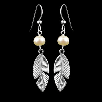 These sterling silver feather earrings have single, round freshwater pearls dangling from the hooks. Below the pearls are long, oval shaped feathers with feather lines cast into the surface of them.