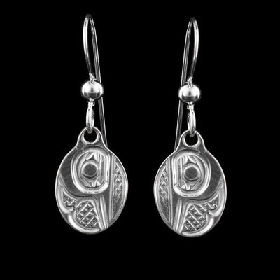 These sterling silver dangle Hummingbird earrings have small, oval hangs dangling from long hooks. The hangs depict the side profile of the head of the Hummingbird with cross hatching designs in the background. The beak of the Hummingbird is pointing down on the hangs.