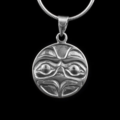 This Eagle pendant is made from sterling silver and is circle shaped. The piece shows the face of the Eagle facing out with both its eyes and large, sharp beak detailed. 