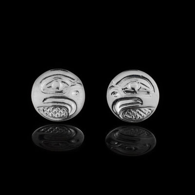 These Eagle stud earrings are made from sterling silver and have circle shaped studs. The head of the Eagle is depicted in a side profile on the studs. His beak and eye are detailed with cross hatching patterns in the background.