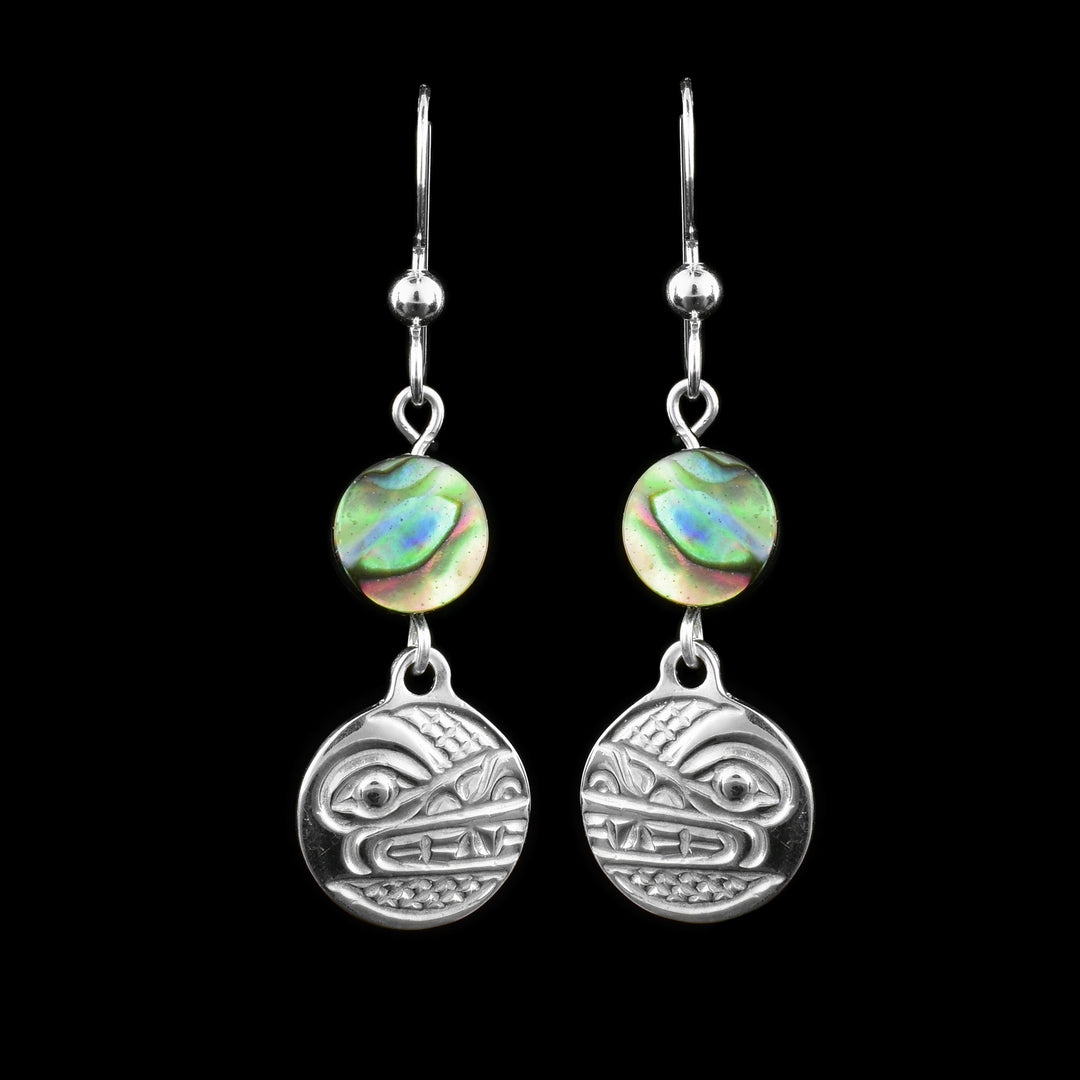 These dangling pearl earrings silver have small, circle hangs made from sterling silver. Below the hooks is a single, round abalone shell charm with the hangs dangling from them. On the hangs, the head of the Wolf is shown at a side profile with its teeth, eyes and nose detailed. There are cross hatching designs in the background of the portrait.