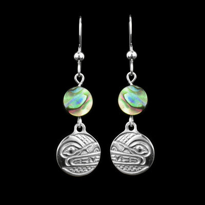These dangling pearl earrings silver have small, circle hangs made from sterling silver. Below the hooks is a single, round abalone shell charm with the hangs dangling from them. On the hangs, the head of the Wolf is shown at a side profile with its teeth, eyes and nose detailed. There are cross hatching designs in the background of the portrait.