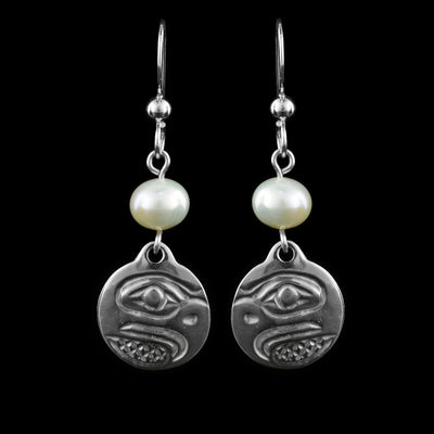 These dangling pearl earrings silver have small, circle hangs made from sterling silver. Below the hooks is a single, white pearl with the hangs dangling from them. On the hangs, the head of the Eagle is shown at a side profile with its beak (curved at the end), eyes and nose detailed. There are cross hatching designs in the background of the portrait.