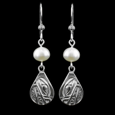 These dangling teardrop earrings have teardrop shaped hangs cast from sterling silver. There is a single, white pearl below the hooks and above the hangs. The head of the Bear is cast into the hangs and its snout is facing down. The mouth is large and takes up most of the hangs. There are cross hatching designs in the background of the portrait.