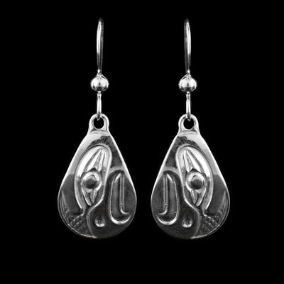 These dangling teardrop earrings have large, teardrop shaped hangs cast from sterling silver. The head of the Eagle is cast into the hangs and its beak is facing down. The beak is curved at the end and takes up most of the hangs. There are cross hatching designs in the background of the portrait.