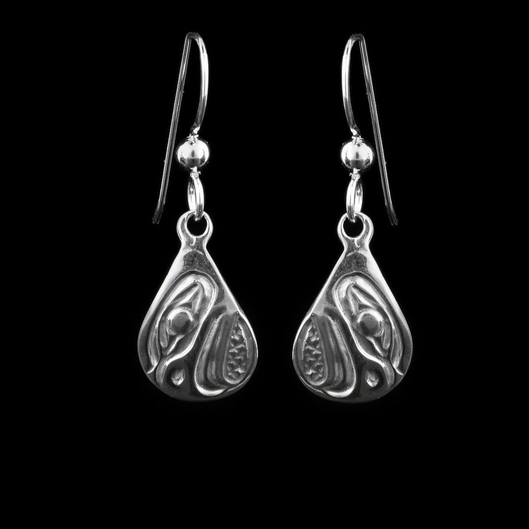 These dangling teardrop earrings have teardrop shaped hangs cast from sterling silver. The head of the Eagle is cast into the hangs and its beak is facing down. The beak is curved at the end and takes up most of the hangs. There are cross hatching designs in the background of the portrait.