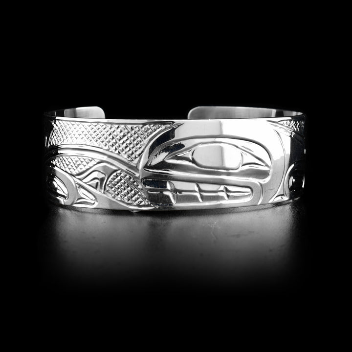 This sterling silver cuff bracelet has depictions of the Orca carved into it. 