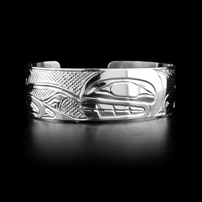 This sterling silver cuff bracelet has depictions of the Orca carved into it. 