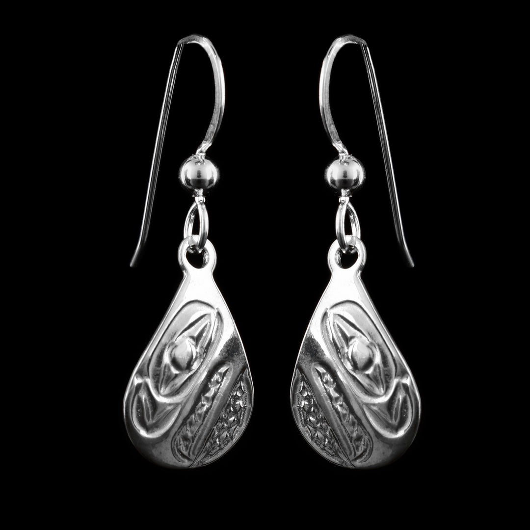 These dangling teardrop earrings have teardrop shaped hangs cast from sterling silver. The head of the Raven is cast into the hangs and its beak is facing down. The beak is large and takes up most of the hangs. There are cross hatching designs in the background of the portrait.