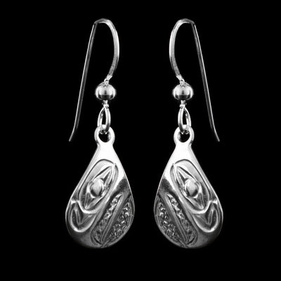 These dangling teardrop earrings have teardrop shaped hangs cast from sterling silver. The head of the Raven is cast into the hangs and its beak is facing down. The beak is large and takes up most of the hangs. There are cross hatching designs in the background of the portrait.