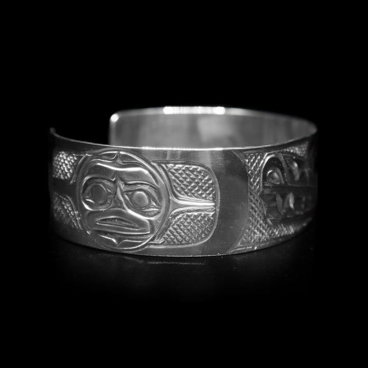 This Wolf and Moon bracelet has a single, wide and sterling silver band with a gap in the back. There is a depiction of the Wolf and the Moon legends carved into the band.