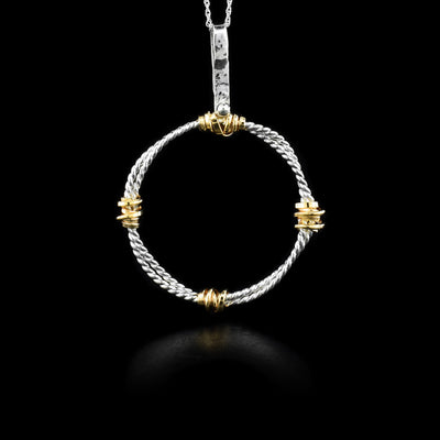 This circle necklace has a long jump ring attached to a coil circle. There are four gold-fill wraps attached on the silver base.