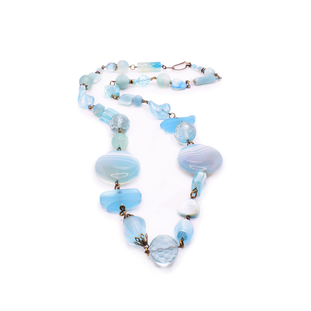 this Honica Coastal Blue necklace. Handcrafted with Amazonite, Agate, and Swarovski Crystals on antique brass, this 69cm piece is a true masterpiece.