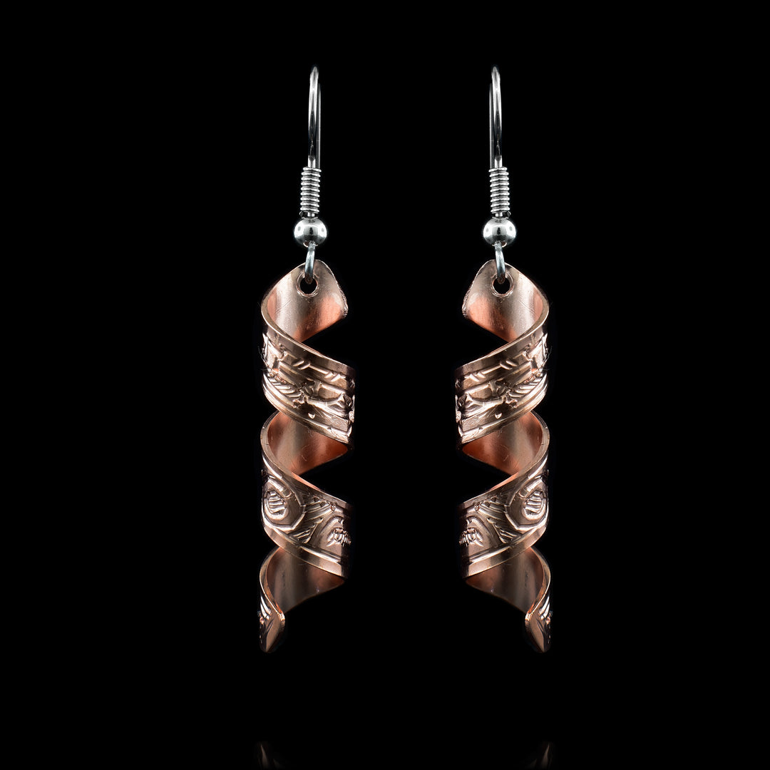 These spiral earrings have hangs made from copper bands that have been curved into horizontal spirals. The copper cylinders drop down and there are depictions of the Eagle carved into them with their beaks facing upwards.