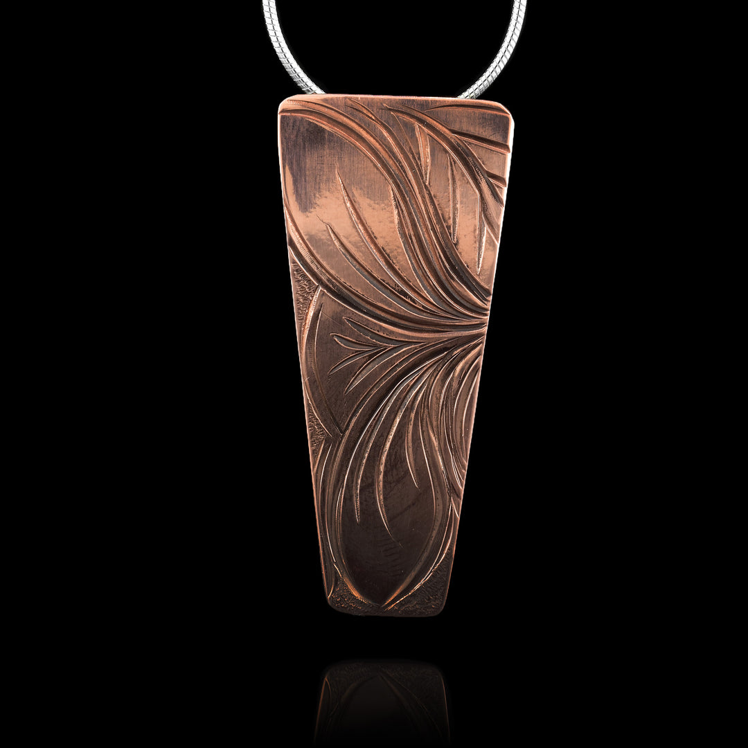 Hand-carved flower copper pendant featuring graceful petal designs on a trapezoid shape.