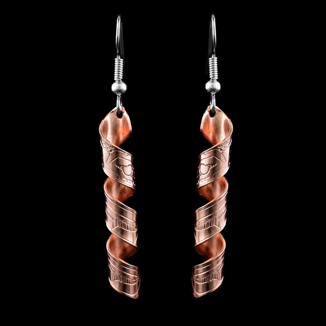 These spiral earrings have hangs made from copper bands that have been curved into horizontal spirals. These copper cylinders drop down and have carvings depicting a side view of the Hummingbird legend with their beaks facing upwards.