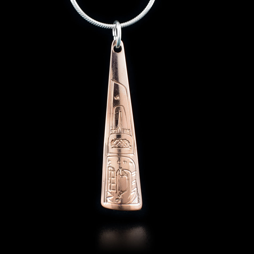 This Orca pendant is made from copper and has a long, thin, and triangular pendant. There is a depiction of the Orca carved into the surface of the pendant.