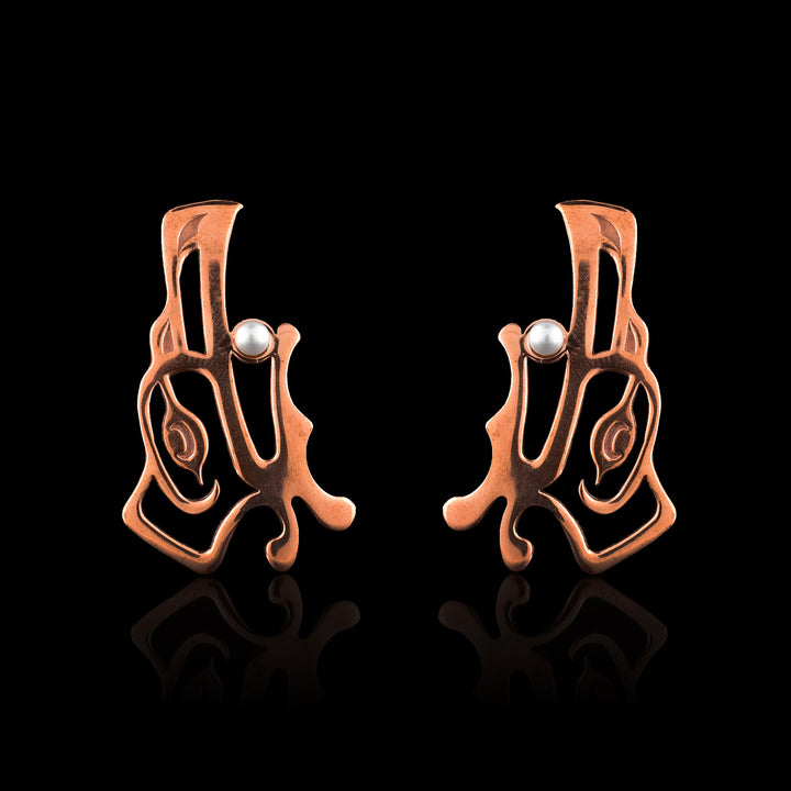 Raven copper drop earrings featuring genuine pearl accents. These unique, handcrafted earrings showcase traditional Pacific Northwest formline art with a high-shine finish.