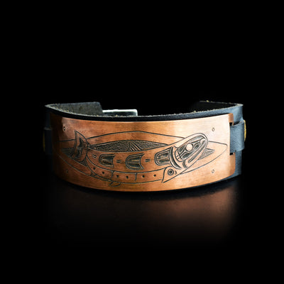 Leather cuff has copper plate with side-view of salmon. Leather is black.