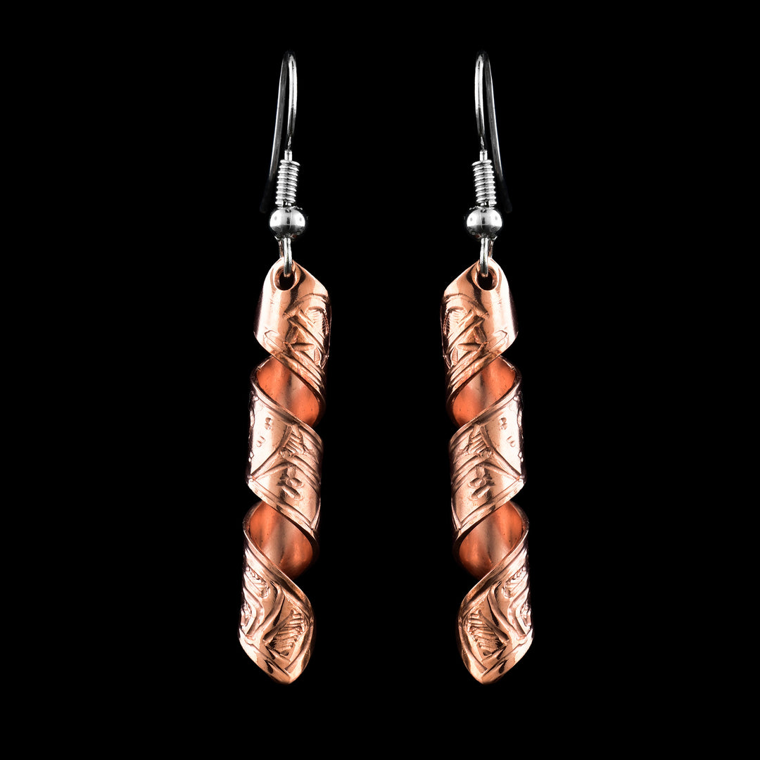 These spiral earrings have hangs made from copper bands that have been curved into horizontal spirals. The copper cylinders drop down and there is a depiction if the Wolf carved into the outside of the bands. The head of the wolf is facing the top of the piece.