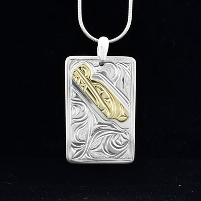 This Wolf pendant is made from sterling silver, 14K gold and has a large, rectangular shape. There is a depiction of the Wolf and designs carved into the surface of the piece and they head of the Wolf is made from 14K gold.