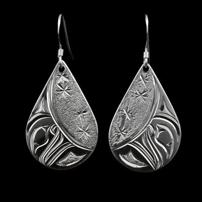 These dangling crescent Moon earrings are made from sterling silver and have wide, teardrop shaped hangs. There are depictions of the crescent shaped Moon carved into the hangs.