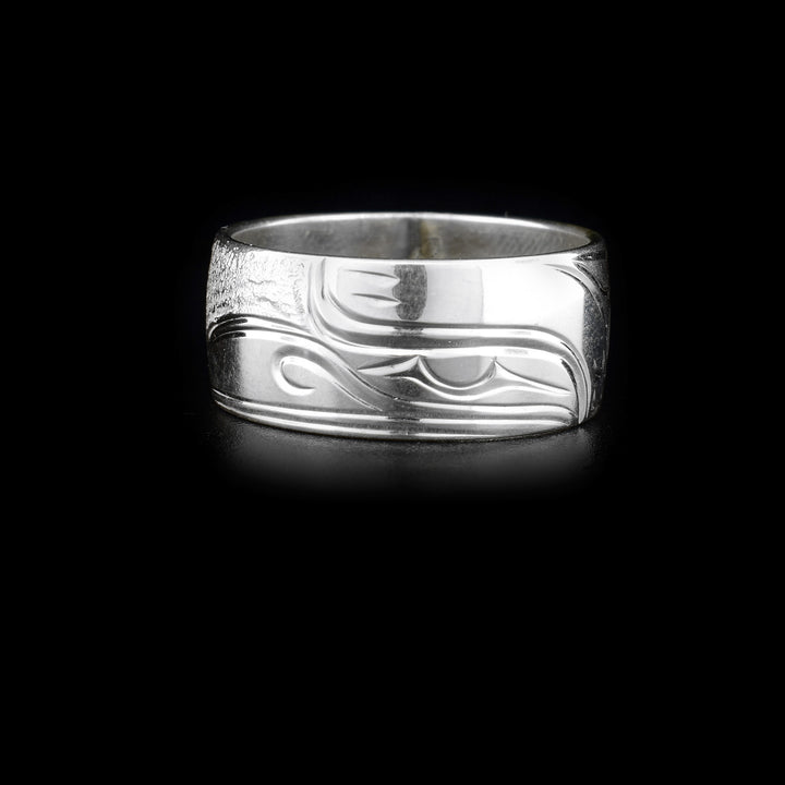This silver band ring is made from sterling silver and has a depiction of the Raven carved into it.