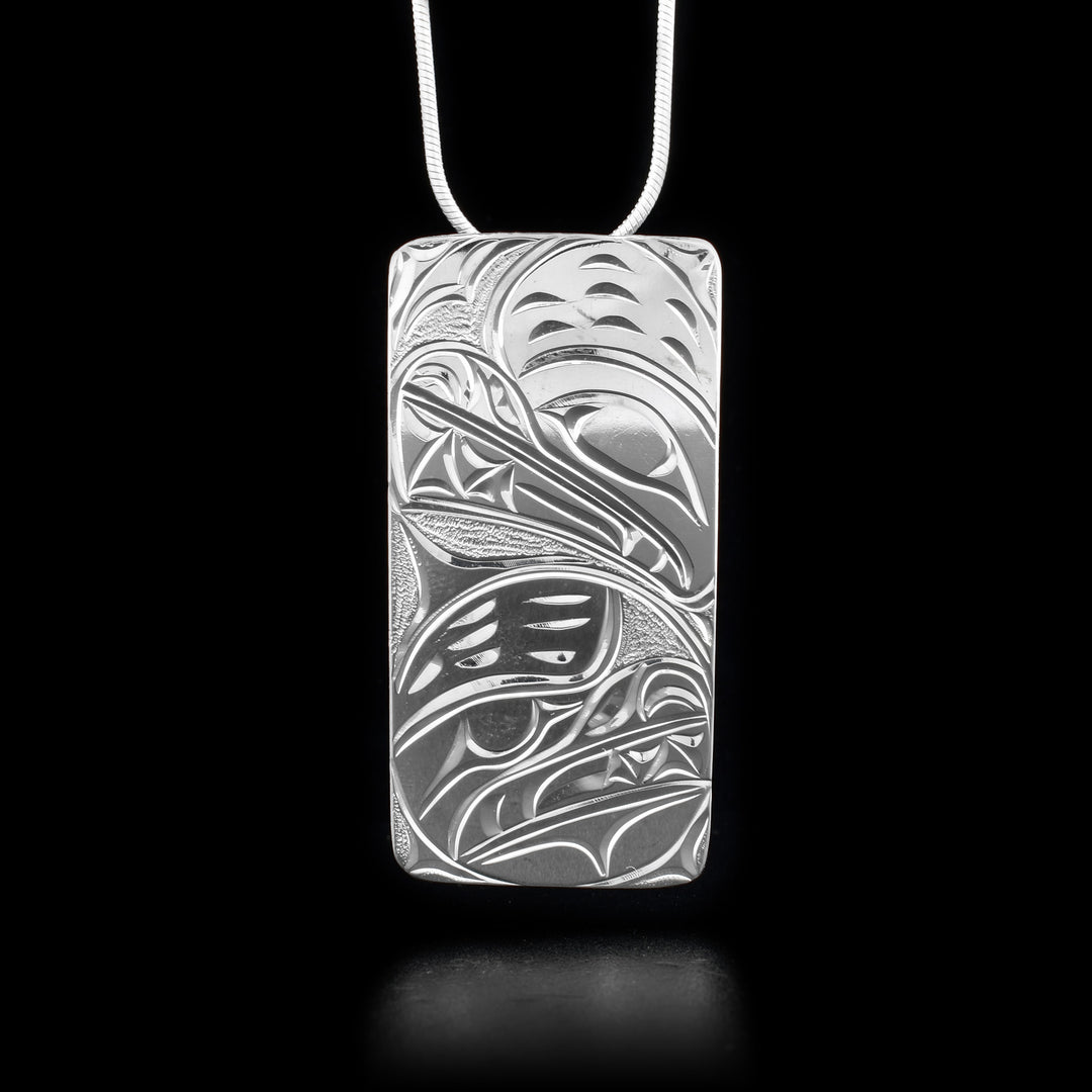 This Bear pendant is made from sterling silver and is large and rectangular. There are depictions of the Bear carved into the surface of the pendant.