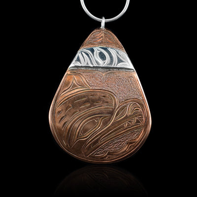 This Moon and Bear pendant is made from copper and sterling silver with a large, teardrop shape. There are carvings on the surface of the piece depicting the Bear, the Moon and other designs. The depiction of the Moon has been done in sterling silver.