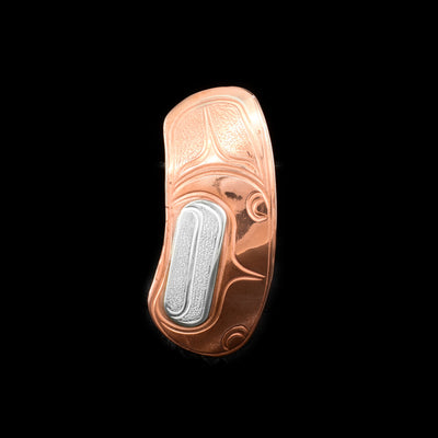 This sterling silver and copper brooch pin is shaped like and has carvings on the surface of it depicting the clam. There are sterling silver designs around the clam.