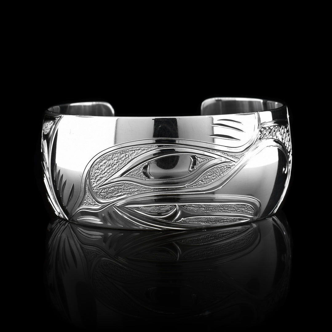 This stunning Eagle bracelet cuff has been made using sterling silver and has a single, wide band with a gap in the back. There is a beautiful depiction of the face of the Eagle that has been intricately carved into the surface of the band. There are dimpled, textured designs made around the negative space of the depiction.