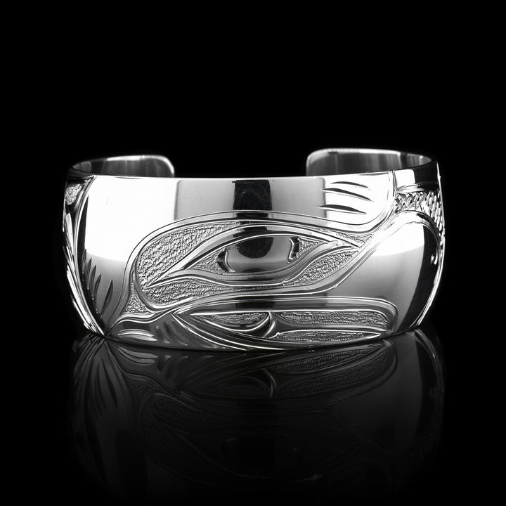 This stunning Eagle bracelet cuff has been made using sterling silver and has a single, wide band with a gap in the back. There is a beautiful depiction of the face of the Eagle that has been intricately carved into the surface of the band. There are dimpled, textured designs made around the negative space of the depiction.