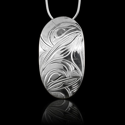 This Hummingbird pendant is made from sterling silver and is large and oval shaped. There are depictions of the Hummingbird carved into the surface of the piece.