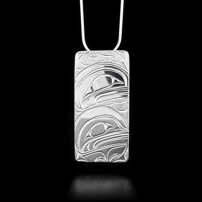 This Orca pendant is made from sterling silver and is large and rectangular. There are depictions of the Orca carved into the surface of the pendant.