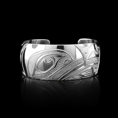 This Orca bracelet cuff has been made using sterling silver and has a single, wide band with a gap in the back. There is a gorgeous depiction of the face of the Orca and it fin carved into the center of the band. There are dorsal fins in the sea depicted on the one side of the band.